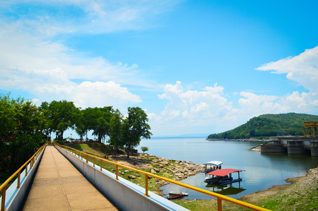 landscape bridge of reservoir river on blue sky and mountain background / bright day on hydroelectric dam at Ubolrat Khon Kaen thailandの写真素材