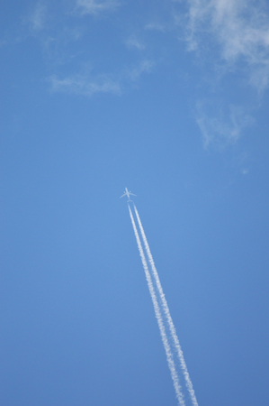 Jet airplane flying the blue sky / trace of the plane in the sky bright dayの写真素材