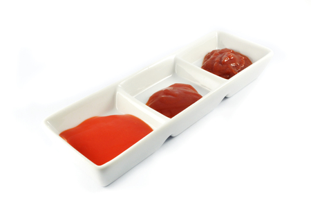 ketchup tomato sauce and chilli sauce in cup isolated on white backgroundの写真素材