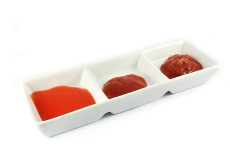 ketchup tomato sauce and chilli sauce in cup isolated on white backgroundの写真素材