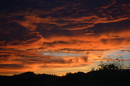 amazing cloud sky sunset / orange dark storm scary dramatic clouds on sunset beautiful with motion clouds over storm in forest summerの写真素材