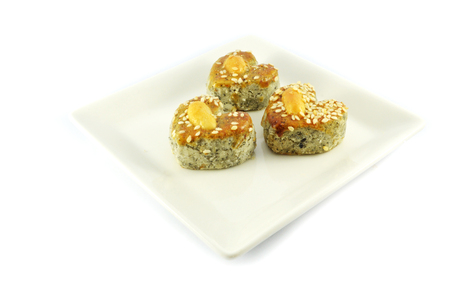 mini cookies isolated / heart shaped of cookies cake with white sesame and  cashew nut on top isolated on white backgroundの写真素材