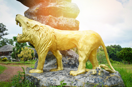golden lion statue / the large statue of lion golden on the rock in the garden parkの写真素材