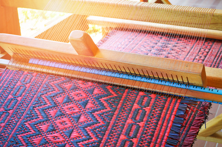 traditional weaving loom for carpets fabric / weaves clothes produces hand in thailand - weaving mat colorfulの写真素材