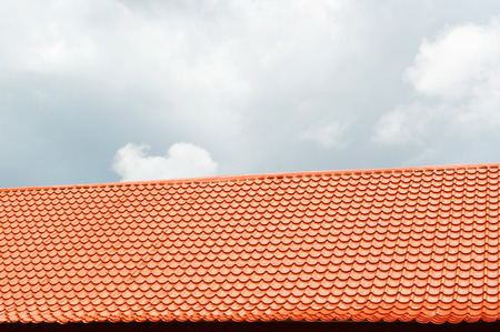 orange roof tile with sky and cloud background / home building construction roof tiles concrete