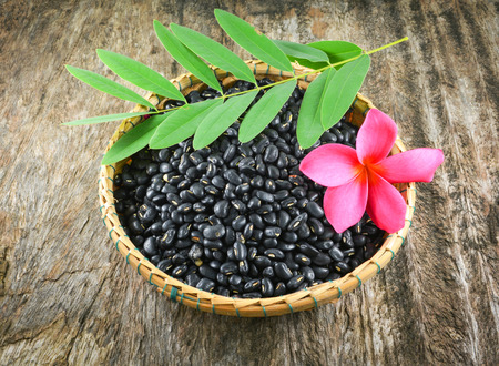 Black bean on basket / black food black beans grain seeds on bamboo basket with pink flower and...