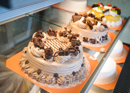 Different types Cake in showcase / tray cake in glass display at store bakery pastry shop - Showcase with sweets chocolate milk Strawberry fruit cakes for sale cake shopの写真素材