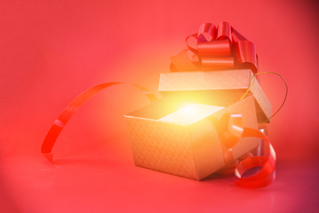 Open Gift Box rays light on red background / red present box with red ribbon bow for Merry Christmas Holiday Happy new year or Valentines day on red background - Surprise Gift Boxの写真素材