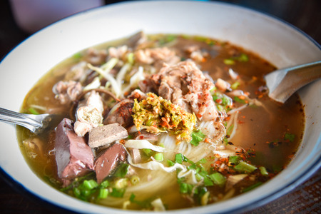 delicious noodles bowl / close up of vermicelli noodles soup spicy with pork stew blood cubes and...