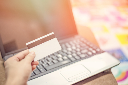 credit card and using laptop easy payment online shopping concept / credit and debit card in hand for shopping online pay in electronic card keyboard notebookの写真素材