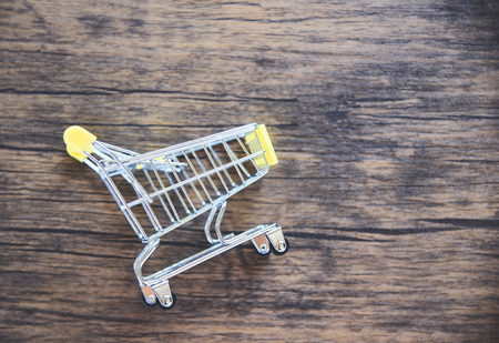 Shopping cart on rustic wooden background / Online shopping black Friday concept with yellow...