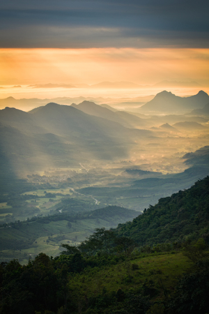 Wonderful sunrise in the morning new day on hill mountain with rays of sunlight shining on the cloud sky - Amazing beautiful mountain range backgroundの写真素材