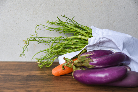Zero waste use less plastic concept / Fresh vegetables organic in eco cotton fabric bags on wooden table - white tote canvas cloth bag from market free plastic shoppingの写真素材