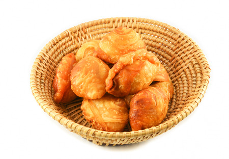 Curry puff pastry for snack dessert with beans and sugar on basket isolated on white backgroundの写真素材