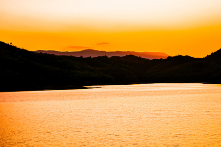 Landscape sunset river yellow sky beautiful silhouette mountain backgroundの写真素材