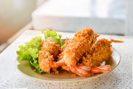 Delicious deep fried shrimps crispy wrapped - butterfly shrimps on plate and lettuce vegetable on top viewの写真素材