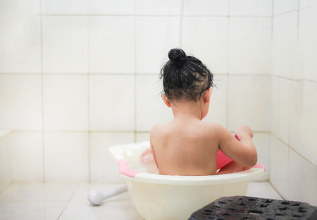 Child shower bathroom / Asia kid  little girl taking a bath and playing waterの写真素材