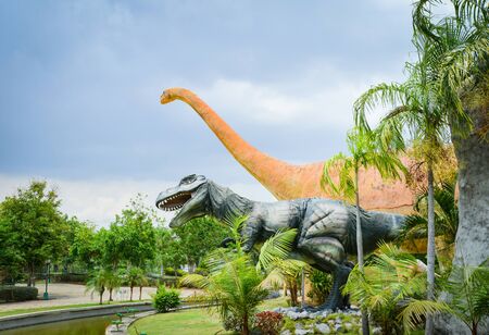 Khon Kaen , Thailand 13 May 2018 : Dinosaur park, different species dinosaur statue in the palm tree gardenのeditorial素材