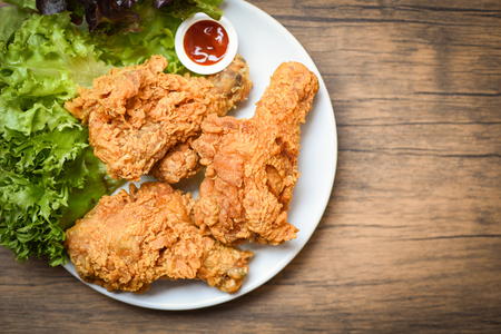 Fried chicken crispy on white plate with ketchup and salad lettuce vegetable on wooden backgroundの写真素材