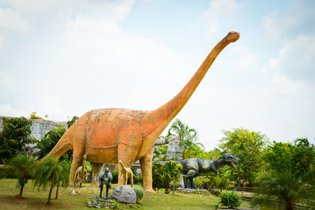 Khon Kaen , Thailand 13 May 2018 : Dinosaur park / different species dinosaur statue in the palm tree gardeのeditorial素材