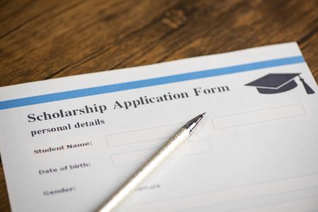 Scholarship application form document contract concept with pen for grants education on wooden tableの写真素材