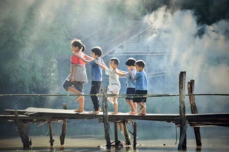 Sakon Nakhon Thailand - July 31 2018 : Asia children boy and girl friend happy funny smile and walking on wood bridge river agricultural farm countryside of living life kids rural peopleのeditorial素材