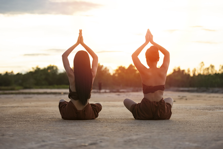 Sunset yoga woman backside on outdoor nature backgroundの写真素材
