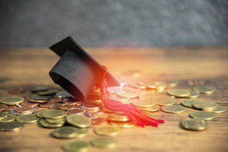 Scholarship for education concept with graduation cap on money coin wooden tableの写真素材