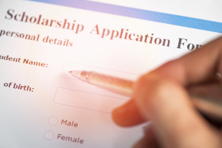 Scholarship application form document contract concept with pen in hand for grants educationの写真素材