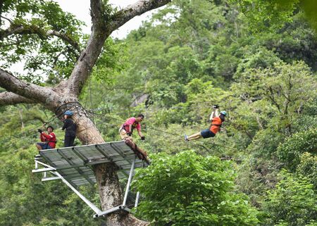 Vang Vieng Laos - 01 July 2017 : Zipline exciting sport adventure activity hanging on the big tree...