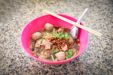 Noodles soup bowl with pork meat ball and vegetables traditional thai and chinese style food of...