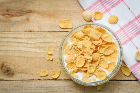 Cornflakes in bowl with milk on wooden background for cereal healthy food breakfast