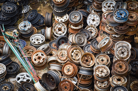 scrap metal / heap of old rusty metal wheel rims in the car dum wheel vehicle wasteの写真素材