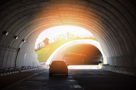 highway road tunnel traffic car speed on street with bright light at end of tunnelの写真素材