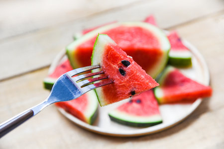 Fresh watermelon slice on wooden tray summer fruit / watermelon on forkの写真素材
