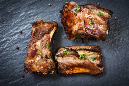 bbq pork ribs grilled with herbs spices served on the dark plate / Roasted barbecue pork spare rib slicedの写真素材