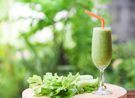Vegetable juice smoothie summer and fresh celery stalk on wooden board with nature green backgroundの写真素材