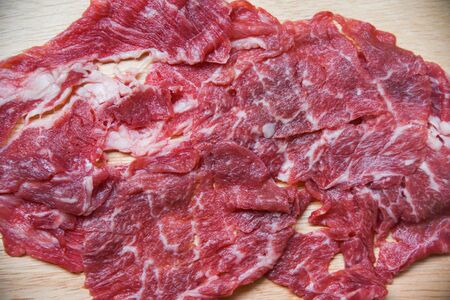 Meat beef slice on wooden cutting board for cooked or Sukiyaki Shabu shabu Japanese foods Asian cuisine / Fresh beef rawの写真素材