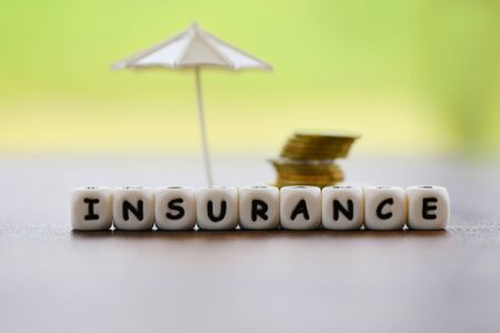 Sales insurance home , car, family concept / White umbrella protecting gold coin security of property insurance claim business finance safeの写真素材