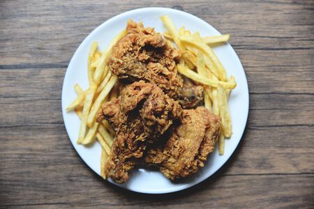 Fried chicken crispy on white plate with french fries on dining table background top viewの写真素材