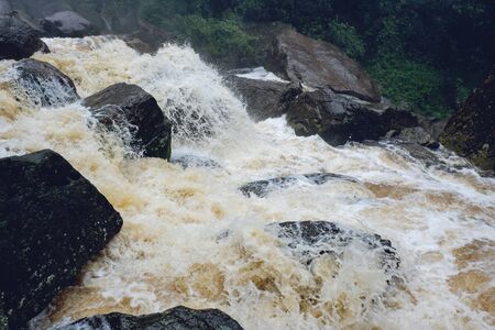 Water flood on river after heavy rain rapids water flow copiously from mountain stream in the forest