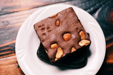 brownies cake on the table / chocolate cake slice with nut in the plate on wooden backgroundの写真素材