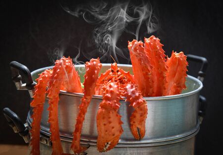 Alaskan King Crab Cooked steamer food on steaming pot seafood and lettuce vegetable with dark background / red crab hokkaidoの写真素材