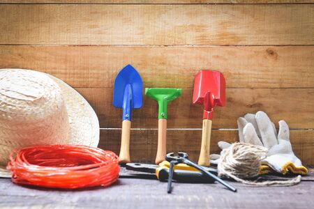 Gardening tools on wooden background with pliers , straw hat , rope , gloves trowel garden equipment