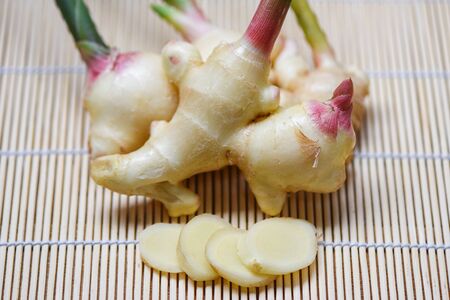 Ginger slice on wooden background / Fresh young ginger for herb medicinal natural and food