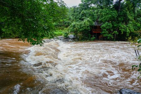 Water flood on river after heavy rain rapids water flow copiously from mountain stream in the forest