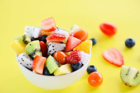 Fruit salad bowl fresh summer fruits and vegetables healthy organic food strawberries orange kiwi...
