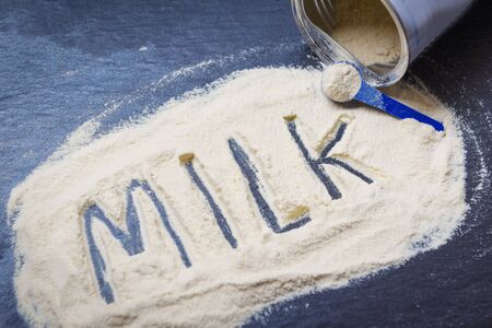 Milk powder on dark background / powdered milk can , food healthy body from protein or for baby conceptの写真素材
