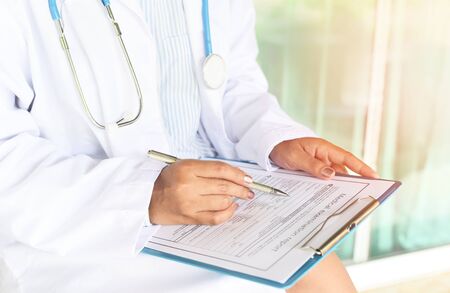 doctor woman asian note on medical record - medical examination report for diagnosis in the hospital...