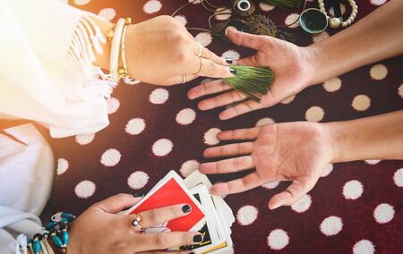 Fortune teller reading fortune lines on hand Palmistry Psychic readings and clairvoyance hands concept with Tarot cards divinationの写真素材